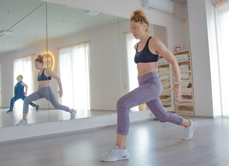 Body Balance в Батуми — студия йоги «Место Силы». Девушка выполняет динамичный выпад с контролем баланса на занятии.