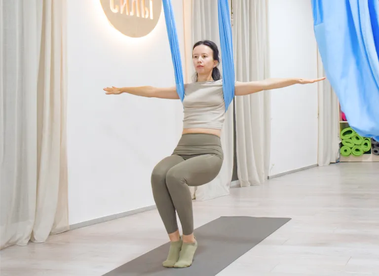 Занятие по направлению «Fly fitness» в студии «Место Силы» в Батуми: преподаватель Оксана Алендукова демонстрирует балансировочное упражнение в подвесном гамаке